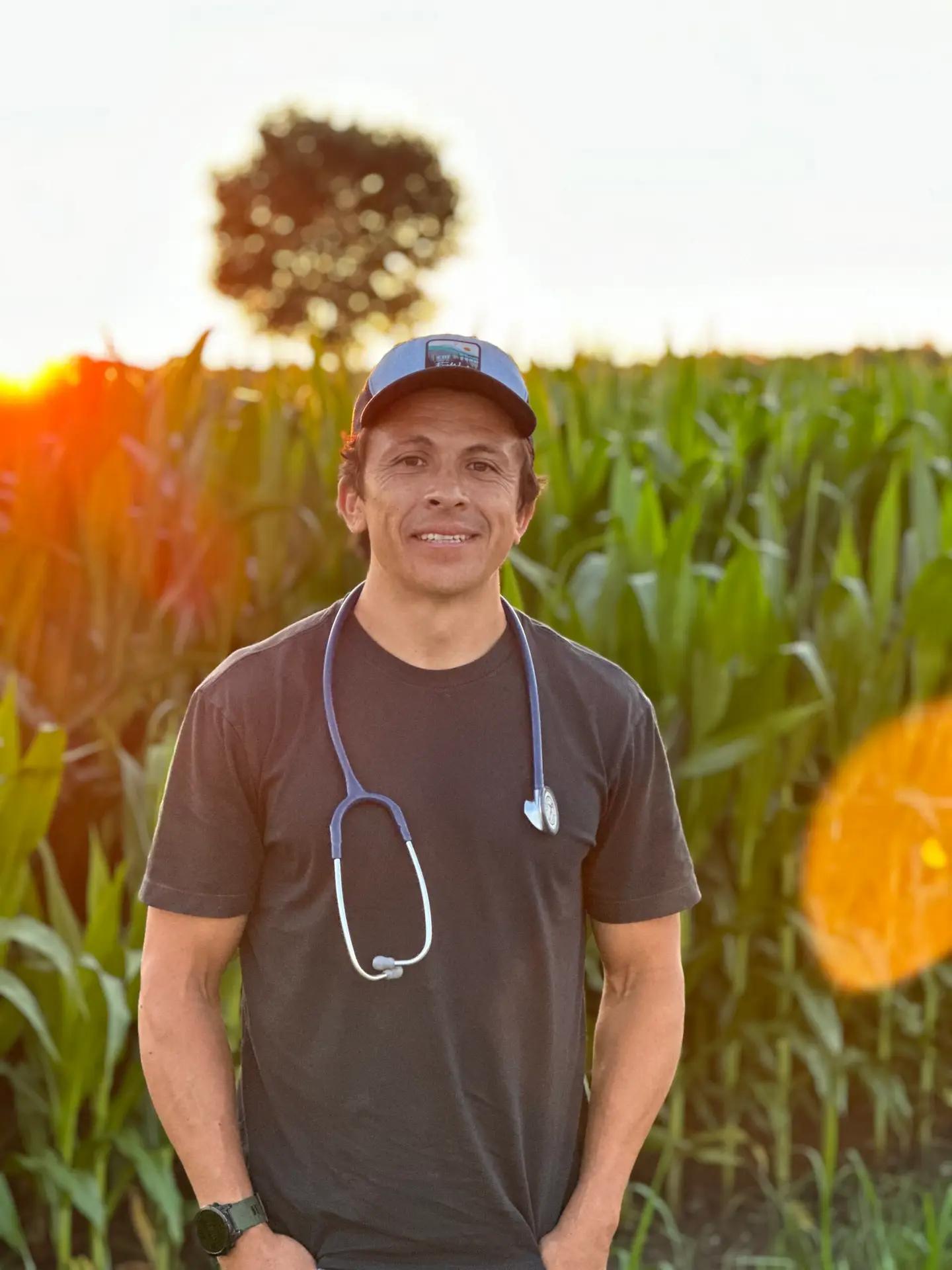 Man in field with stethoscope at sunset.